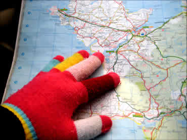 Mano con guante de colores señalando ruta en el mapa